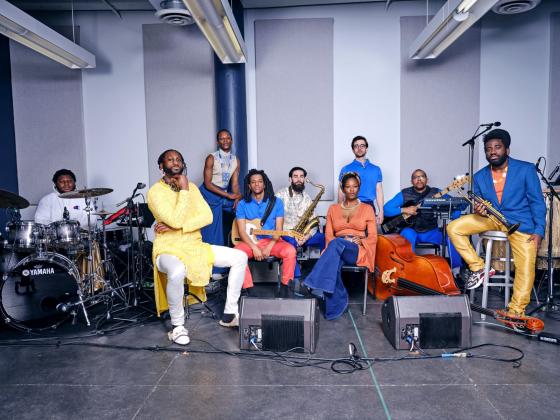 Mwenso & The Shakes wearing bright yellow, blue and orange colored clothing