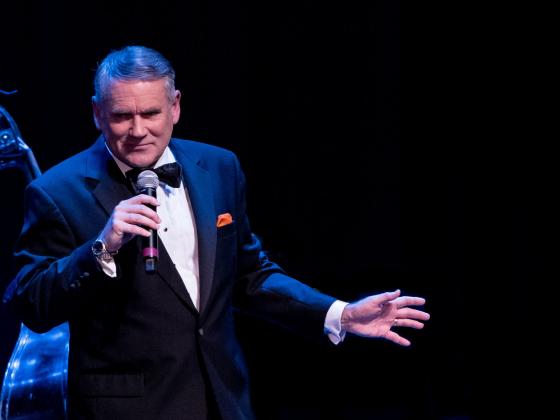 Dave Halston singing on stage wearing a tuxedo