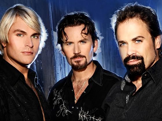Three men - two with brown hair and beards, one with blond hair, wear black shirts