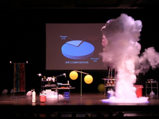 pie char of air composition on screen with smoke and other science related materials on stage