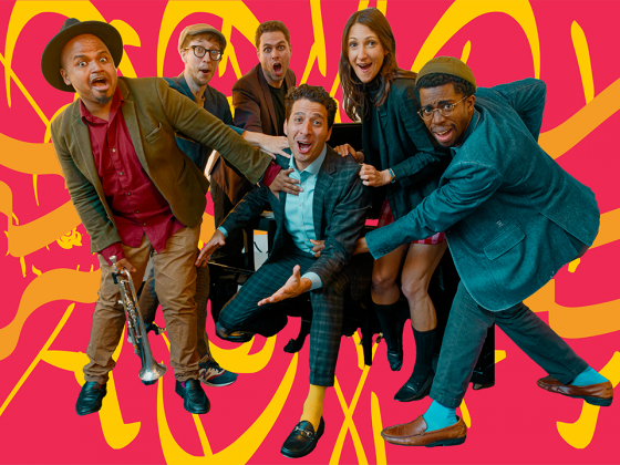 A group of six people are gathered together, looking at the camera with a red and yellow background