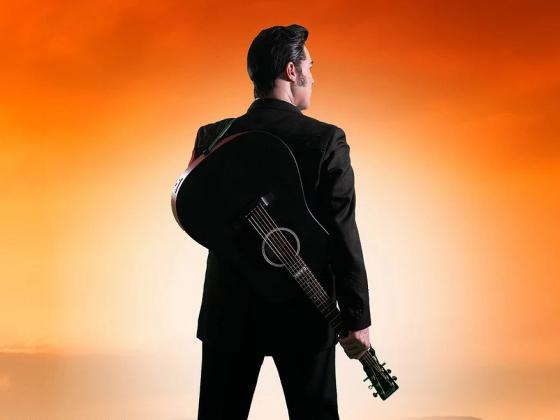 Chandler Center for the Arts presents Walkin the Line: A Tribute to Johnny Cash A man in black has his back to us, standing on railroad tracks with a guitar on his shoulder