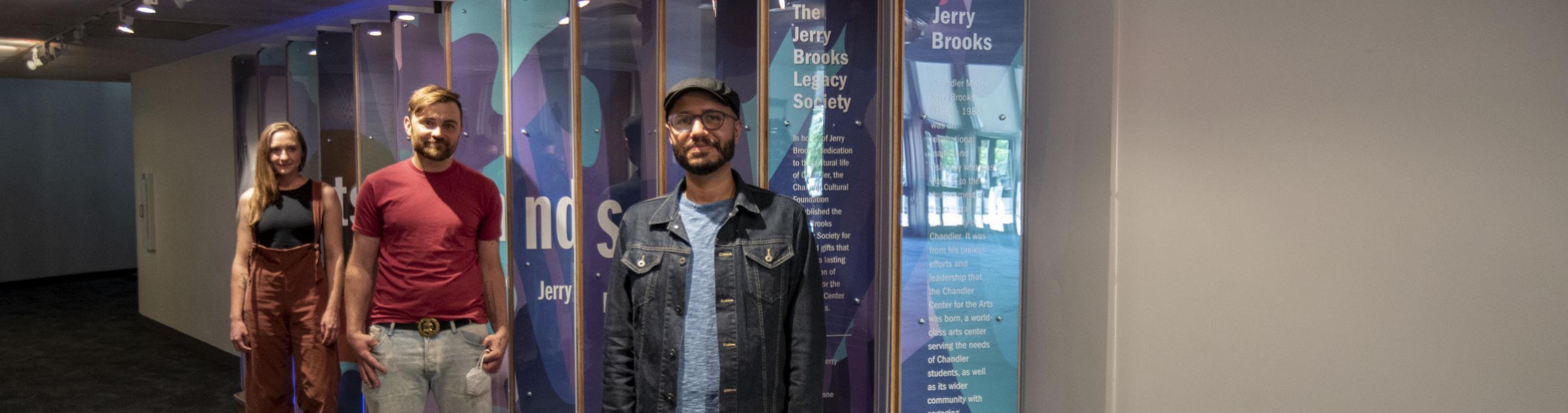 Local Artists Safwat Saleem, Ben Lewis and Chelsea Hickok stand in front of the interactive donor wall at the CCA