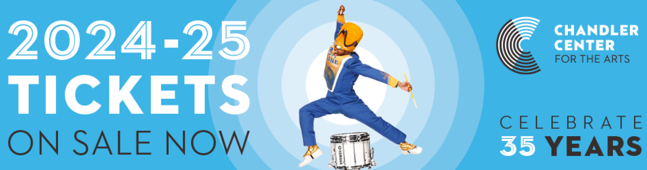 A drum major is mid-jump in the middle of a blue background