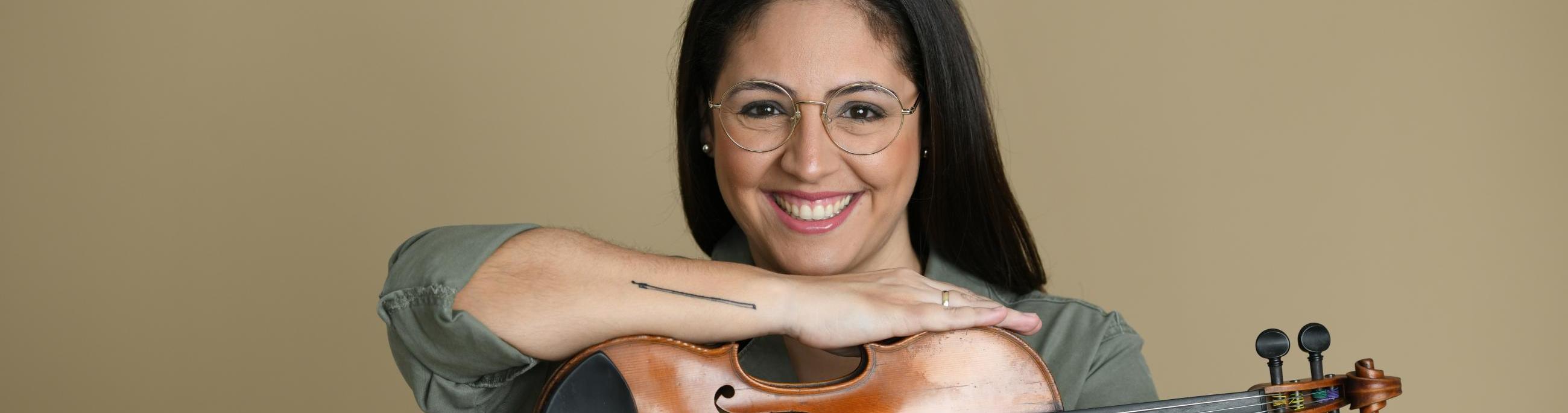 woman with dark hair and glases holding a violin 