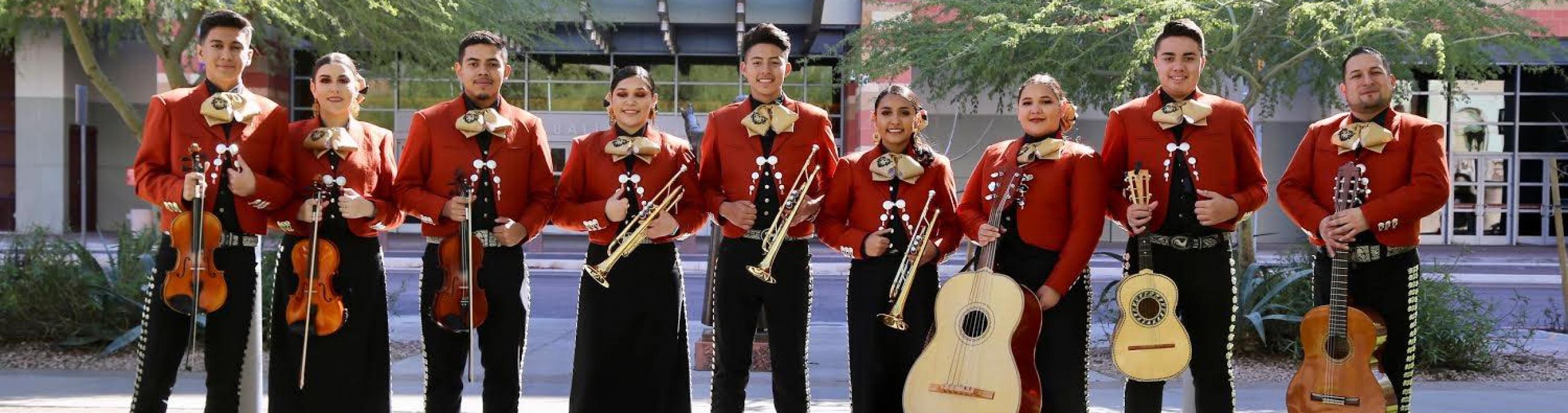 Mariachi Corazon del Valle pose outdoors with their instruments.