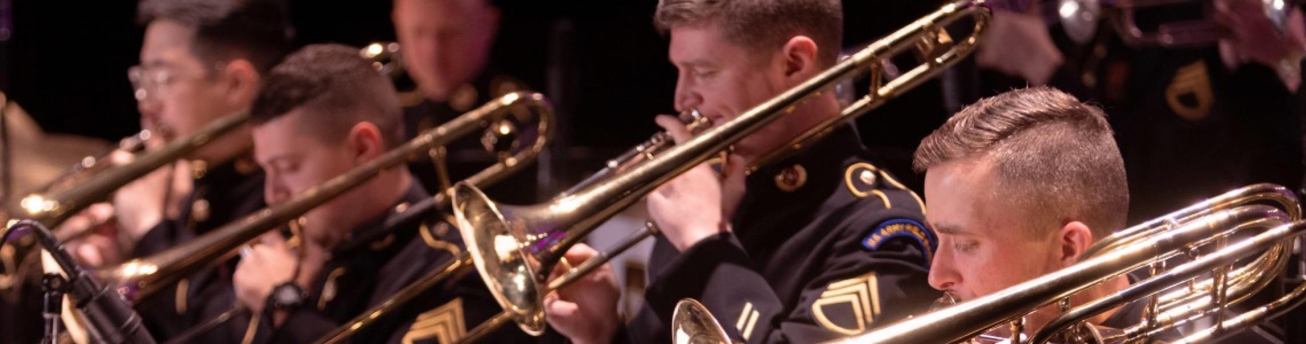 men playing trombones wearing dark uniforms