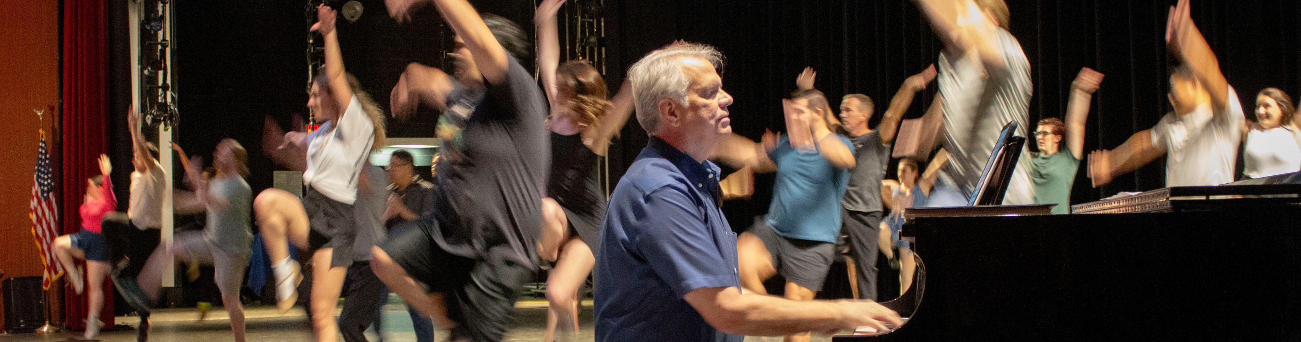 pianist playing while a theatrical audition takes place behind him.
