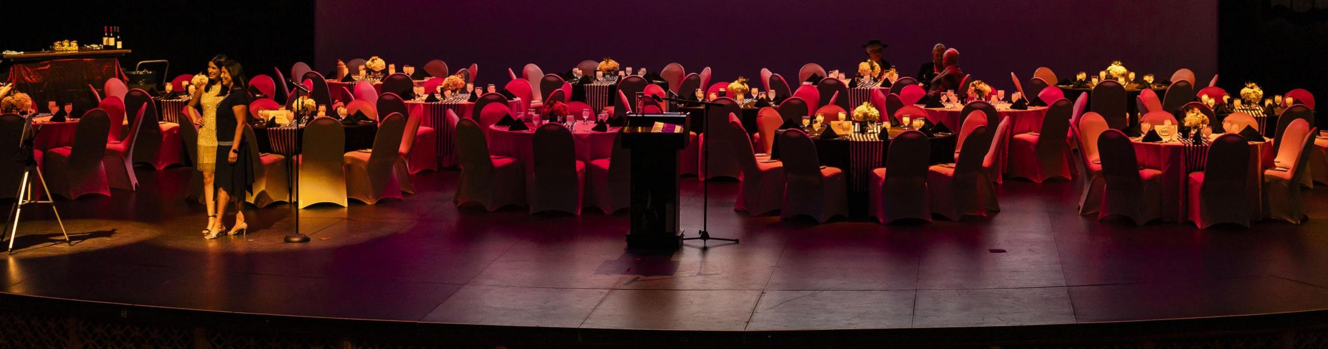 Round tables on top of the mainstage, decorated for a fundraising event