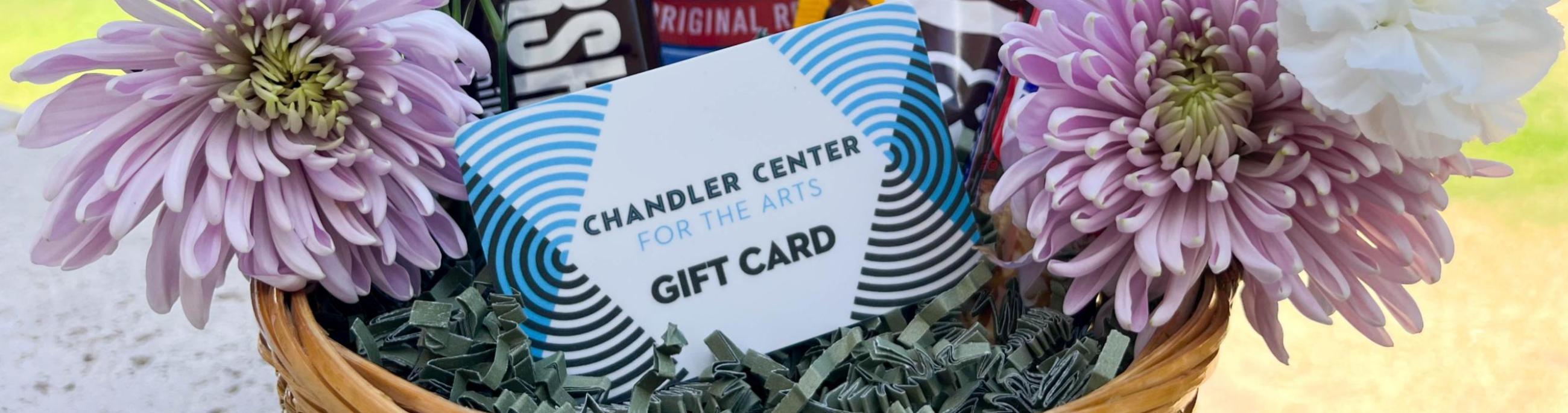 CCA gift card sitting in a basket along with flowers and candy.