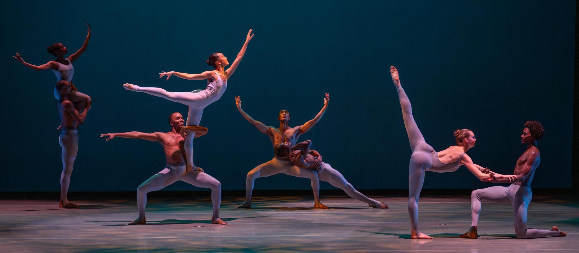8 dancers, each paired in different poses on stage