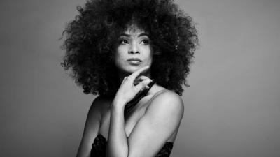 In this black-and-white photo, singer Kandace Springs rests her chin on her hand and looks off into the distance.