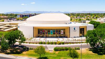 Aerial view of the front of a performing arts center with a blue sky in the background