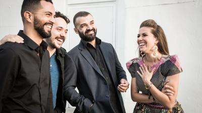 Caro Pierotto laughs with three band members.