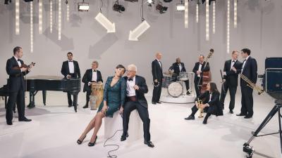 white room with people in suits and dresses standing around looking at each other