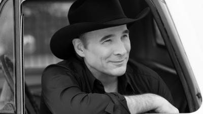 white man with black hat in black and white photo looking outside a car window