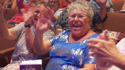 Group of women sitting in the CCA theatre, clapping and enjoying the Free Summer Concert Series