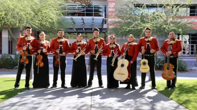 Mariachi Corazon del Valle pose outdoors with their instruments.
