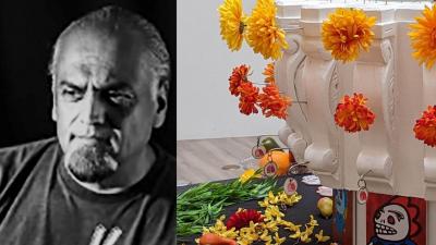 A black and white photo of a bearded man with an image of an altar covered in colorful flowers