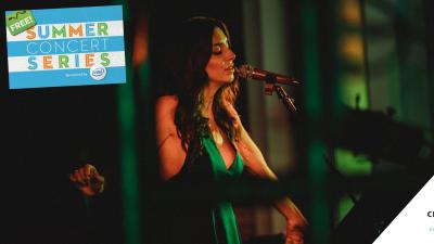 Kim Weston, wearing a green dress, sings into a microphone.