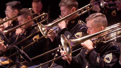 men playing trombones wearing dark uniforms