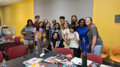 A group of 12 diverse teenagers pose with three adult mentors