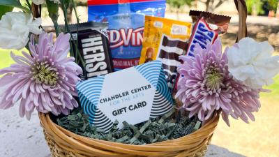 CCA gift card sitting in a basket along with flowers and candy.
